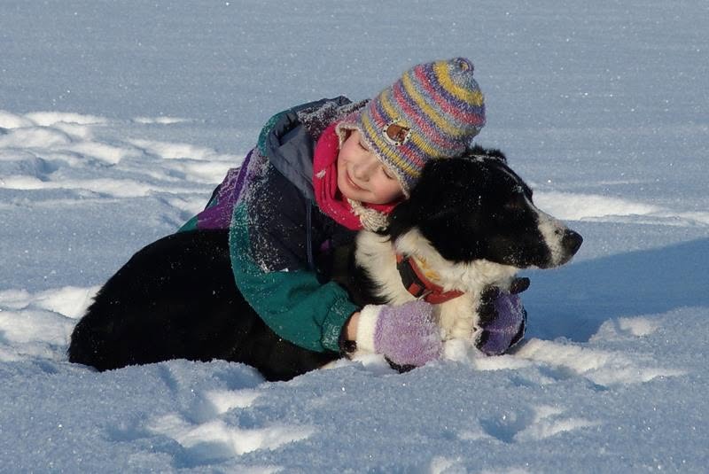 Ein Kind umarmt Marlin vertrauensvoll im Schnee